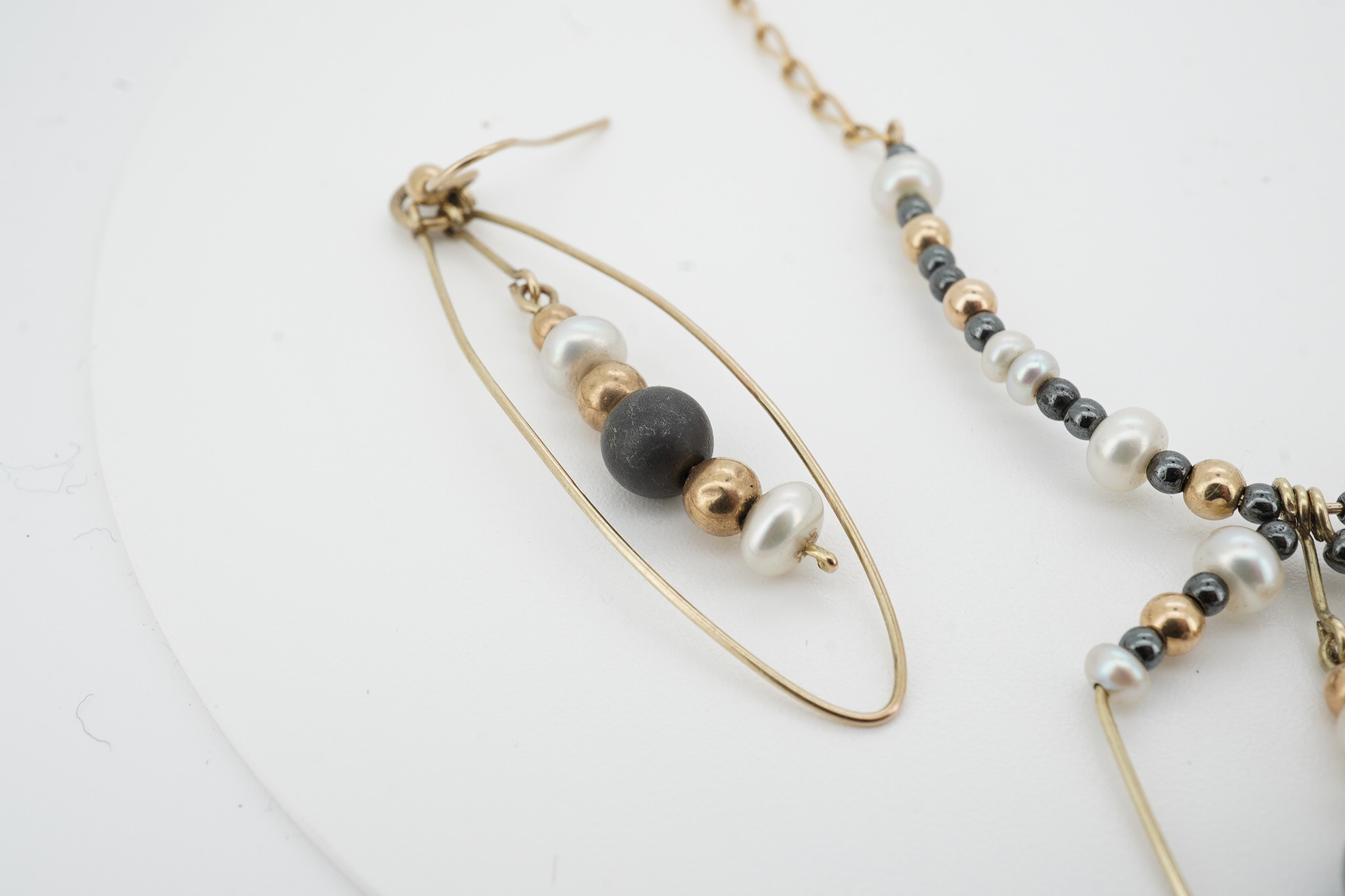 A modern Uno-A-Erre 9ct gold seed pearl and hematite cluster set necklace, approx. 40cm, with a pair of similar drop earrings, gross weight 10 grams. Condition - fair